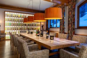 a long table in a restaurant with chairs and lights at Defereggental Hotel & Resort in Sankt Veit in Defereggen