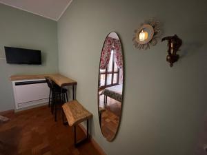 a mirror on a wall with a chair and a table at BellaVista in Saluggia