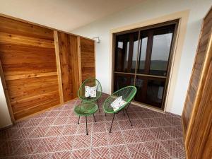 two green chairs and a table in a room at BellaVista in Saluggia