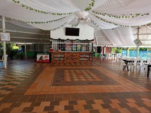 a large white tent with a table and a television at Finca Ecoturística Canaguaros in Tauramena
