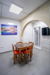 a dining room with a wooden table and chairs at The Oyster - F in Il-Furjana