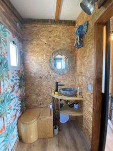 a bathroom with a sink and a stone wall at Chalet Majoie in Les Mages