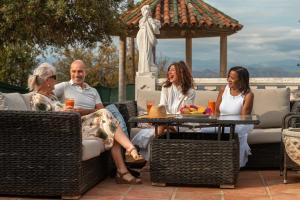 a group of people sitting around a table on a patio at Bronlara in Alhaurín de la Torre
