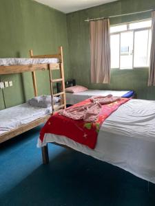 a bedroom with two bunk beds and a window at Quarto simples no centro in Sete Lagoas
