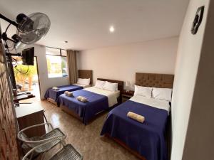 a hotel room with two beds and a fan at Huacachina Desert House in Ica +96 photos
