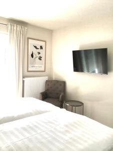 a bedroom with a bed and a chair and a television at Fewo Anna in Bernkastel-Kues