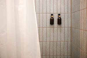 a shower with two black bottles on a tile wall at Casa Serdán in Puebla