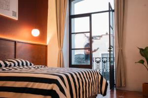 a bedroom with a zebra print bed with a window at Casa Serdán in Puebla +15 photos