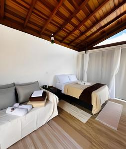 a bedroom with a bed and a couch at Vinhedo Villarejo - Chalés do Vinhedo in Paty do Alferes