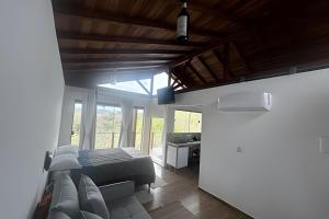 a bedroom with a bed in a room with windows at Vinhedo Villarejo - Chalés do Vinhedo in Paty do Alferes +50 photos