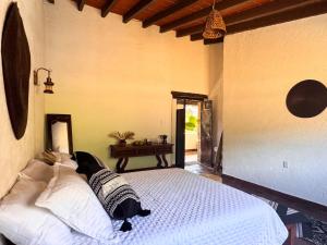 a bedroom with a white bed in a room at Umbral Habitación Rústica con Desayuno Incluido in Tepoztlán