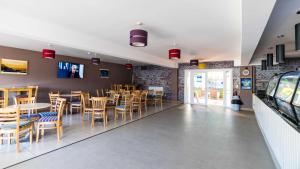a dining room with tables and chairs in a restaurant at Joesphine Newquay Bay 37 in Newquay Bay Resort