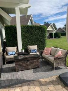 a patio with two chairs and a bench on a house at Qualicum Landing Beachside Home in Qualicum Beach +5 photos