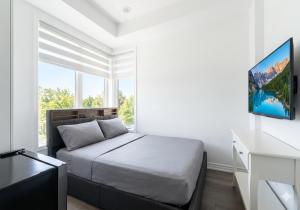 a white bedroom with a bed and a window at Keppel Circle Residence in Brampton