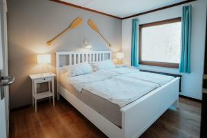 a large white bed in a room with a window at Ferienwohnung Westerlicht - Apartment am Leuchtturm - De Torenhoeve in Nieuw-Haamstede +50 photos