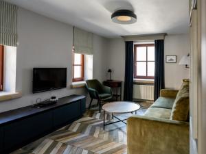 a living room with a couch and a tv at Arte-locum Apartamenty przy Rynku in Wrocław