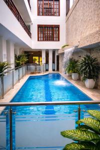 an indoor pool with blue water in a building at Hotel Casa Esmeralda in Cali