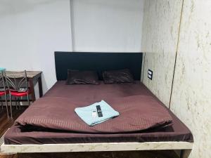 a bed with a remote control on top of it at Hidden key guest house in Bhubaneshwar
