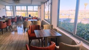 a dining room with tables and chairs and windows at Marco Polo in Tangier