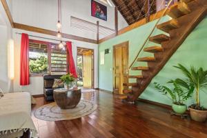 a living room with a staircase in a house at Tropical 2BR Bungalow with Private Pool in Taravao