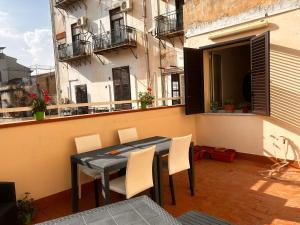 a table and chairs on the balcony of a building at Antiche mura in Palermo