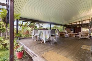 a covered deck with a table and chairs at Peaceful 2BR Garden Bungalow in Taravao