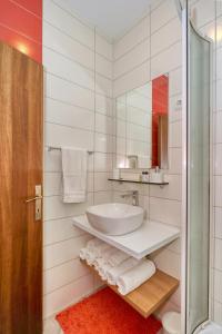 a white bathroom with a sink and a mirror at Rooms & Apartments 72 in Zadar +57 photos
