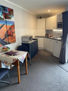 a small kitchen with a table and a microwave at Quiet restful unit with seaviews in Auckland