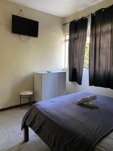 a bedroom with a bed with a tv on the wall at Hotel no centro in Sete Lagoas