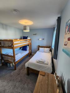 a bedroom with two bunk beds and a table at Sea Esta, The Bay, 2 bedrooms, patio garden, parking nearby, 2 dogs welcome in Filey +25 photos