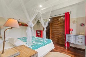 a bedroom with a bed with a canopy at Charming Tropical Retreat with Private Pool in Taravao