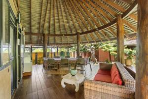an outdoor patio with a couch and a table at Charming Tropical Retreat with Private Pool in Taravao