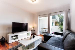 a living room with a couch and a flat screen tv at Casa Nobrega in Caniço