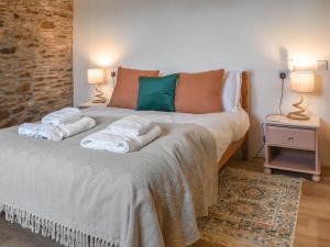 a bedroom with a large bed with towels on it at Shire Cottage - Uk50029 in Liskeard