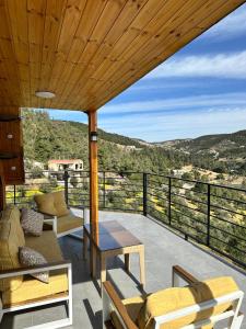 a patio with a table and chairs on a balcony at أكواخ المها oryx cottage in Ajloun