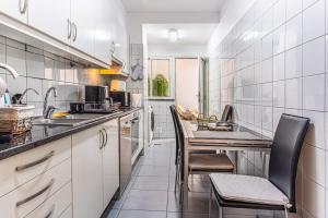 a kitchen with white cabinets and a table and chairs at Casa Nobrega in Caniço