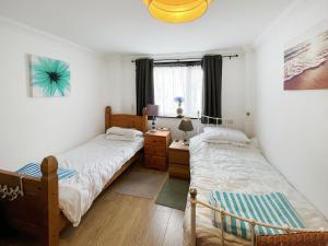 a bedroom with two beds and a desk and a window at Turner Villa in Ramsgate +5 photos