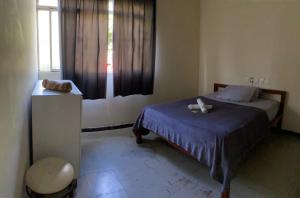 a small bedroom with a bed and a window at Hotel econômico in Sete Lagoas