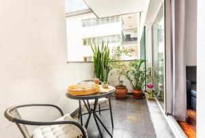 a small table on a balcony with plants at Casa Nobrega in Caniço