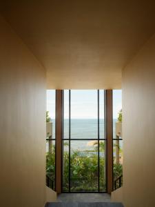 a room with a large window looking out at the ocean at Rosewood Mandarina in Monteón