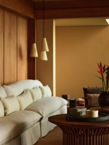 a living room with a white couch and a table at Rosewood Mandarina in Monteón