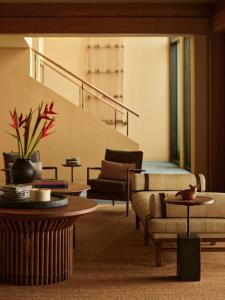 a living room with couches and tables and stairs at Rosewood Mandarina in Monteón