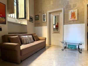 a living room with a couch and a glass table at Dimora 400 - nel cuore del Centro Storico di Lecce in Lecce