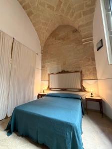 a bedroom with a blue bed with two tables at Dimora 400 - nel cuore del Centro Storico di Lecce in Lecce