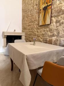 a table with a white table cloth on it with chairs at Dimora 400 - nel cuore del Centro Storico di Lecce in Lecce