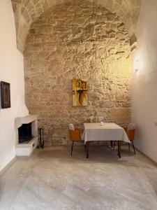 a dining room with a table and a stone wall at Dimora 400 - nel cuore del Centro Storico di Lecce in Lecce