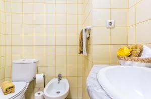 a bathroom with a toilet and a sink at Casa Nobrega in Caniço +14 photos