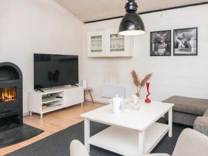 a living room with a white table and a fireplace at 4 person holiday home in Blåvand in Blåvand