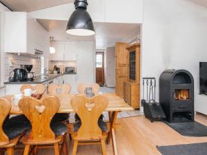 a kitchen and dining room with a wooden table and chairs at 4 person holiday home in Blåvand in Blåvand