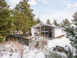 a small white house in the snow at 4 person holiday home in Blåvand in Blåvand